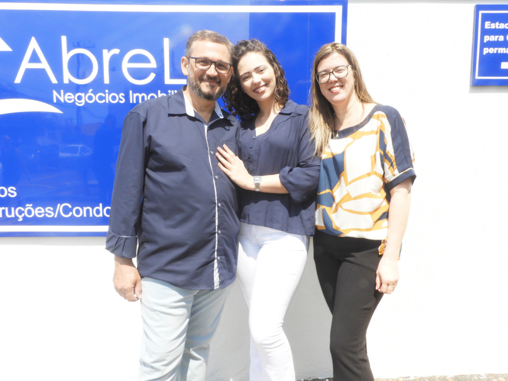 No próximo dia 23, a AbreLar - Negócios Imobiliários, comemora um ano de atividade. Os sócios-proprietários, Flávio Prates e Rosely estão brindando o sucesso da empresa, juntamente com sua filha Mariane. Na foto o registro da família em dia de inauguração da AbreLar.