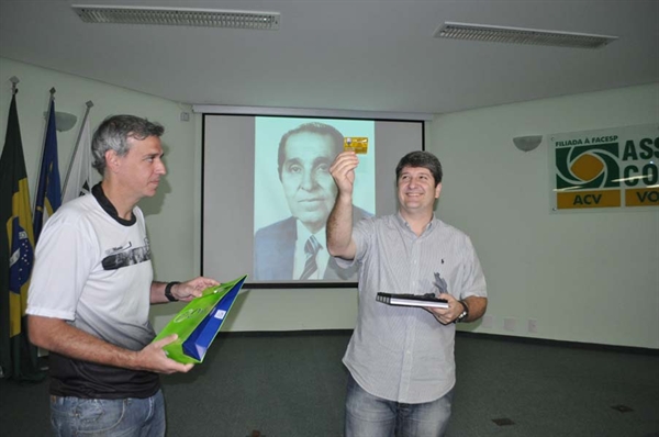 Junior Marão mostra carteirinha em homenagem ao seu pai (foto ao fundo)