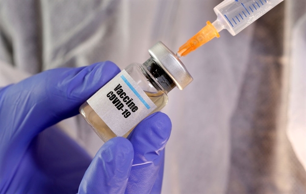 Mais de 160 vacinas estão sendo desenvolvidas em todo o mundo, segundo a OMS. Mulher segura frasco com a inscrição "Vacina Covid-19" em foto do dia 10 de abril de 2020 (Foto: Dado Ruvic/Reuters)