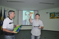 Junior Marão mostra carteirinha em homenagem ao seu pai (foto ao fundo)