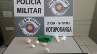 Com o rapaz foram localizadas várias porções de maconha, crack e cocaína, além de certa quantia em dinheiro (Foto: Divulgação/Polícia Militar)
