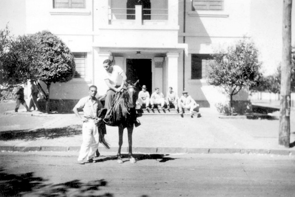 Uma verdadeira relíquia: Getúlio Paes a cavalo no centro da cidade. A foto é de 1954. O prédio da Prefeitura era no centro, onde hoje está a Concha Acústica. Neste flagrante o professor Getúlio Augusto Paes (em cima do cavalo) conversa com o seu amigo Joaquim (do Óleo). Nosso colaborador Dagoberto Mira Alves tentou identificar o pessoal que aparece sentado na porta da Prefeitura. Infelizmente não foi possível. A foto é de Getúlio Paes. 
