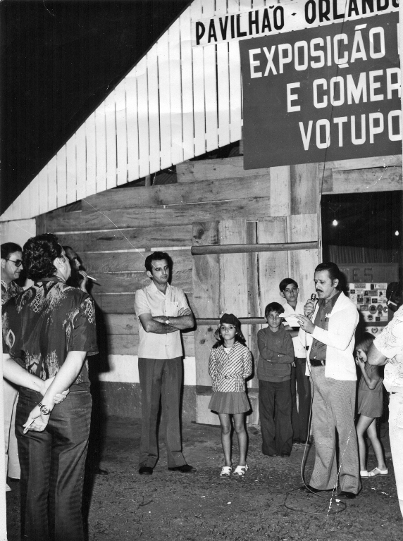 Ano 1982 – Uma solenidade marcou a inauguração do pavilhão da Indústria e do Comércio durante a Exposição Agropecuária, Comercial e Industrial de Votuporanga.Coube ao então vice-prefeito Ra-mes Cury o discurso de abertura oficial da amostra. O seu pronunciamento foi ouvido atentamente pelo então vereador Antonio Trombone (centro) e seus colegas da Câmara que aparecem na foto: dr. Wilson Roncatti e dr. Joaquim Figueira da Costa. Podem ser identificados também o então presidente do Sindicato Rural e organizador da festa, Herculano Bereta. Foto é do nosso arquivo.