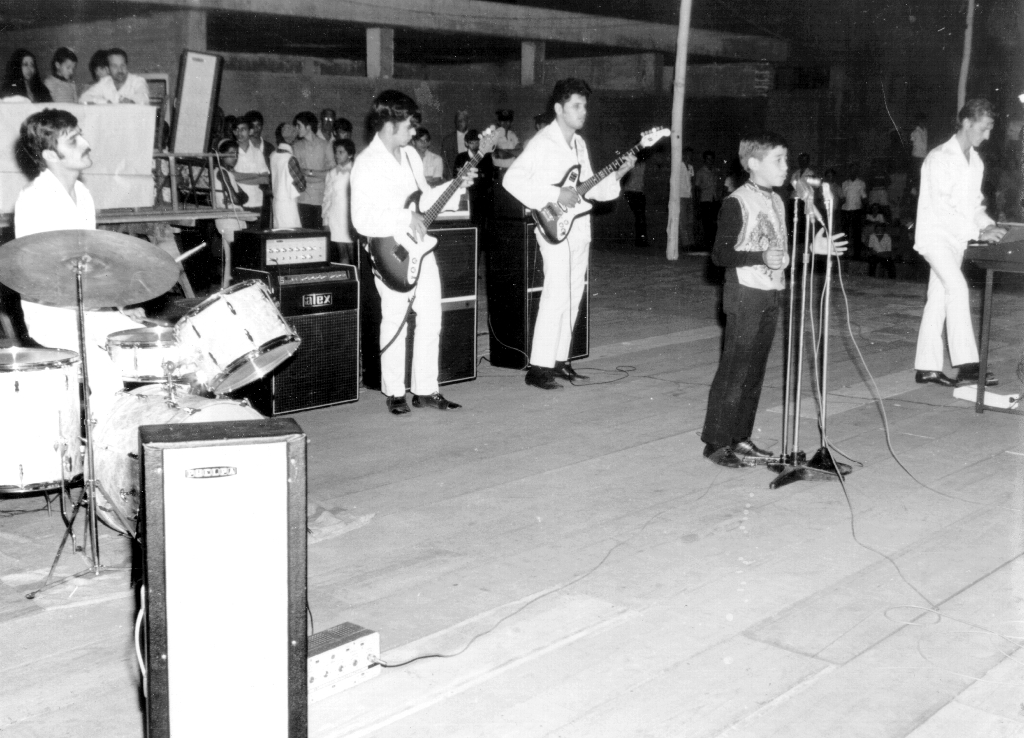 O conjunto “Blue Star”, do Adézio Bronhara, foi a sensação nos bailes dos anos 70. A foto foi feita na Concha Acústica e o conjunto acompanha os participantes do concurso “A Mais Bela Voz”, promovido pela Secretaria da Cultura do Município. O cantor Wainer (foto) foi o vencedor em 1971. Na bateria, Carlito Carreteiro, no contra-baixo, o saudoso Amós e, no órgão eletrônico, o Adésio Bronhara. Era o tempo dos bons festivais de música na Concha sempre lotada.