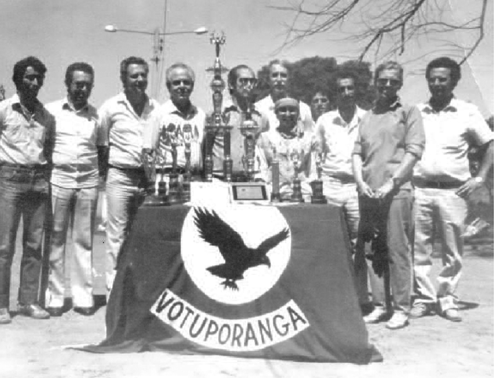 Ano 1984 - Os troféus simbolizam uma conquista importante. O Colégio Técnico Agrícola de Votuporanga foi Campeão Estadual da Agro-Olimpíada, disputada em Presidente Prudente. Da esquerda para a direita: Elcio (vigia), Otávio Falchi (coordenador pedagógico), Nivaldo Melara (Delegado de Ensino), Prof. Valdir Gonçalves de Lima (supervisor de ensino), Prof. Uélinton Garcia Peres (diretor do Colégio Agrícola), Antônio Flávio Belone (professor de educação física), Eva Maria (professora de criações), Dagoberto José Mira Alves (professor de cultura), Maria Lúcia Vargas (professora de geografia e diretora do grupo teatral) e o professor João Nucci (vice-diretor do C.T.A.). O evento deu-se no dia 12 de setembro de 1984.
