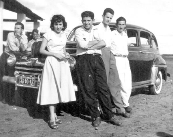 A espera do avião - Esse pessoal estava no antigo aeroporto da cidade (hoje Chácara da Aviação) esperando um voo de São Paulo que fazia escala por aqui nos anos 50. Consta que este carro era o único na cidade a serviço da empresa para buscar o piloto no campo de aviação. Aparecem na foto a partir da esquerda: Maria Antonia de Castro Cury, Denizart Vidigal, Jesus Silva Mello e Primo Beraldi (o dono do carro). A foto pertence ao álbum da família Cury.