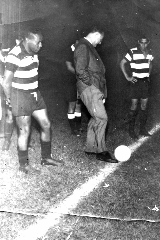 Ano 1959 - Esta é uma foto histórica e documenta a inauguração dos refletores do Estádio “Barão da Serra Negra”, na cidade de Piracicaba. O conhecido Fifi, com a camisa do “XV de Novembro de Piracicaba”, está atento ao “pontapé inicial” da partida dado pelo então governador de São Paulo Dr. Adhemar de Barros. No fundo aparece um outro jogador: Celso, que depois do XV jogou no São Paulo FC. Esse time do XV se apresentava com a seguinte formação: Orlando, Orlando Maia, Cardinali e Dema: Biguá e Gatão: Silvio, Fifi, Graciano, Celso e Valdir. O jogador Fifi chegou na AA Votuporanguense em 1962, contratado pelo empresário Nasser Marão. Muitos dos que viram ele jogar apontam Fifi como “o melhor” que vestiu a camisa alvinegra de Votuporanga. Esta foto é dele: Francisco Santana, o Fifi.