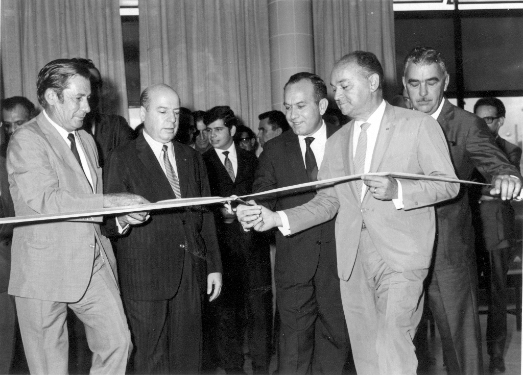 Início da década de 70. A agência local do Banco do Brasil, instalada na Rua São Paulo, no prédio hoje ocupado pela Caixa Econômica Federal, estava recebendo um sistema avançado de equipamentos. Solenemente, o BB de Votuporanga era aparelhado pelo Novo Sistema - Máquina de Contabilidade NCR. Para o ato de lançamento estava presente o diretor do Banco do Brasil, sediado no Rio de Janeiro, Boaventura Farina. Na foto, a partir da esquerda: Orlando Mastrocola (Presidente do IBC - Instituto Brasileiro do Café), Boaventura Farina (diretor do BB), Cristovam De Haro (Presidente da Associação Comercial), Dr. Ultimatum Fava (Presidente da Câmara Municipal), e Pedro Sanches (gerente da agência local do Banco do Brasil). 