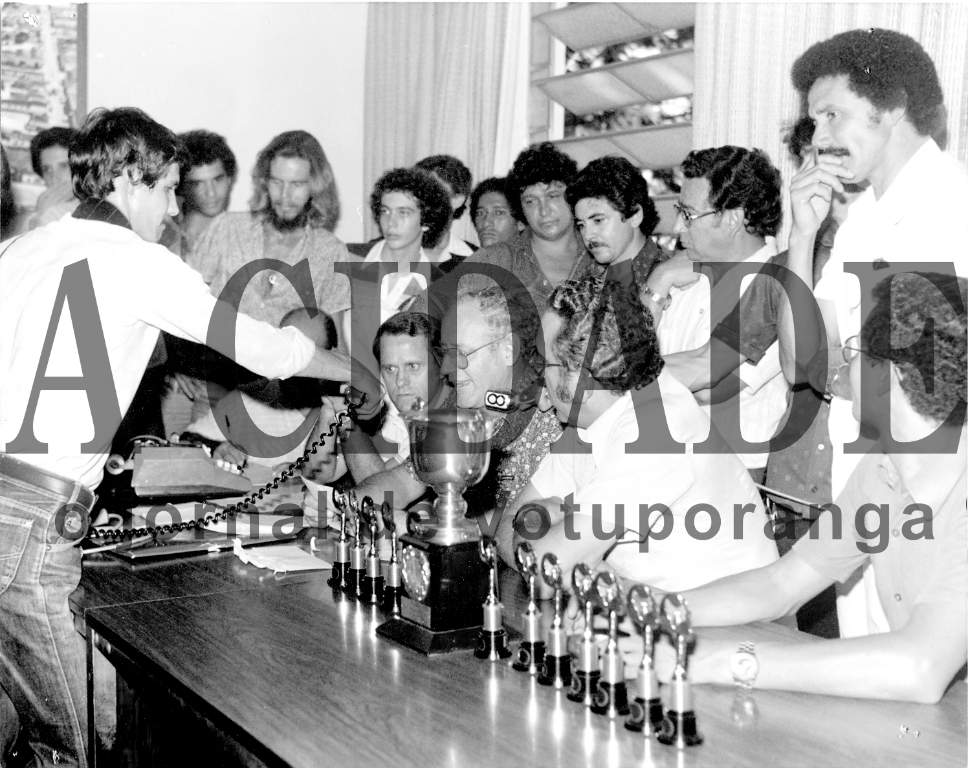 O tão aguardado veredicto dos jurados do Carnaval de Rua de Votuporanga era um momento de tensão de todos os participantes do desfile. Nesta foto, o presidente da Comissão Organizadora,  Jaime Alvares Gil,  revela o resultado anunciando os melhores carnavalescos daquele ano. Ao lado dele, o então chefe de gabinete da Prefeitura Reinaldo  Záccara Campos e o prefeito João Antonio Nucci. Aparecem ainda o famoso batuqueiro Borboleta, o advogado e jornalista Anisio Garcia Martin e o vereador e presidente da escola “Mulata Dengosa”, Arnaldo Santa Fé Trindade. O repórter com o microfone é o saudoso Édison Geraldo Palmieri.


***Confira mais desta coluna em nossa edição impressa e online para assinantes.