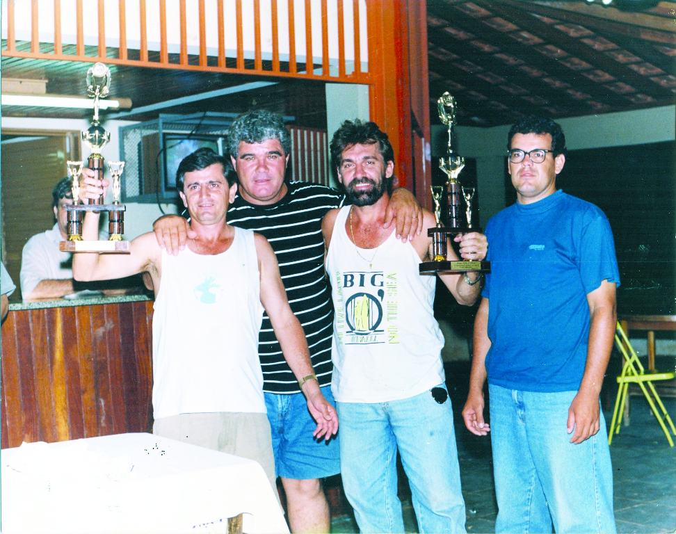 Ano 1981 – No Assary Clube de Campo, o concorrido Campeonato de Truco. Este foi o momento da entrega dos troféus aos campeões. A dupla vencedora foi formada por José Munhóz Corrêa (o Rico) e Antonio Margiote, que mostram os troféus recebidos. Entre eles, convidado para festejar a conquista, aparece o saudoso Antonio Polidoro (Tonhão). Na direita, representando o Assary, o diretor de esportes da época. A foto é do álbum de José Munhóz Corrêa (o Rico).