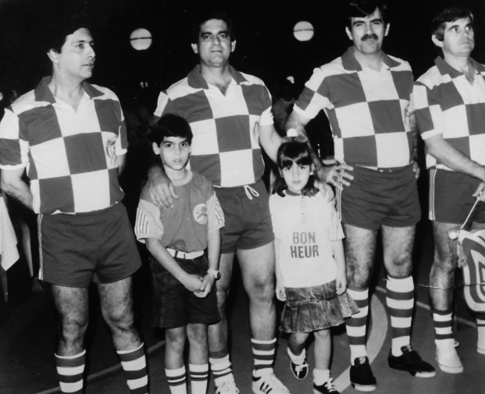 Com esta camisa quadriculada, o Maringá EC, mais conhecido como time do Frei Arnaldo, foi o “bicho-papão” do futebol de salão na década de 60. O nome de Maringá  deu-se por ser formado com apoio de Maringá Materiais de Construção, empresa de propriedade do saudoso comerciante e esportista Antônio Frederico. A equipe tinha jogadores que, de fato, faziam diferença. Na foto, Fifo (falecido no domingo passado), Rui Marão, João Abbas (Chapa) e Escudeiro. Impossível falar desse time sem lembrar também os atletas Baiano e Palestra. Os meninos da foto (mascotes) não conseguimos identificar. A foto é do arquivo pessoal de João Abbas.