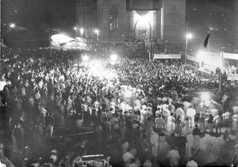 Comício: Nabuco e Viscardi - Veja a praça da Matriz lotada na noite de 12 de julho de 1959. O talentoso fotógrafo Takeo Sato (Foto Votuporanga) registrou essa preciosidade. Veja na esquerda, ao fundo, como era a Barraca da Quermesse. Naquele dia, a Igreja Matriz Nossa Sra. Aparecida ainda se apresentava sem reboco. Foi essa multidão que elegeu naquele ano, para o seu primeiro mandato, o prefeito Hernani de Mattos Nabuco e para vice-prefeito o advogado Octávio Viscardi (que hoje empresta o seu nome ao plenário da Câmara Municipal).A foto pertence hoje ao Museu Rapassi. Colaborou: Dagoberto José Mira Alves (Dago)