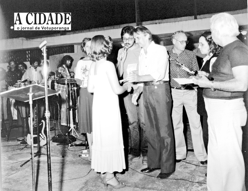 O saudoso presidente da Câmara, Otaviano Nogueira, nesta foto, faz a premiação no palco da Concha Acústica. O registro é dos anos 70, quando Votuporanga realizava durante a administração do prefeito João Antonio Nucci, a Semana da Cultura que revelava os talentos locais. Aparecem na foto o radialista José Antonio (Rádio Cidade), o então chefe de gabinete Reynaldo Zaccara Campos e o jornalista e escritor Edward Corurupe Costa.