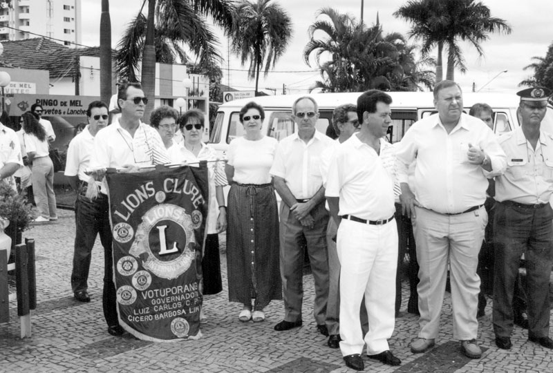 Dia da Bandeira no Lions - A foto é do dia 19 de novembro de 1996. Na praça Cívica (em frente a Concha Acústica), um grupo de associados do Lions Clube de Votuporanga reuniu-se com autoridades para a comemoração do “Dia das Bandeira”. Da esquerda para a direita: Antonio de Lima (ao fundo), Olívio Fajardo (segurando o estandarte do Lions), Evanir Alves dos Santos Fajardo, vereador Osório Casado, jornalista João Carlos Ferreira, o prefeito Pedro Stefanelli Filho e o então Comandante da 3ª Cia da Polícia Militar, Capitão Nélson Torres.A foto é da Secretaria de Educação e Cultura.