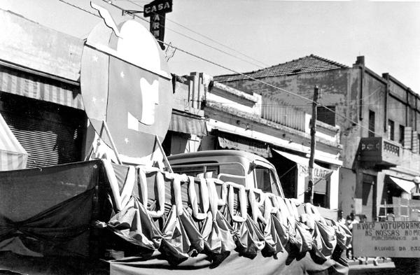 Um carro alegórico no desfile de aniversário da cidade. A foto é do dia 8 de agosto de 1960 e exalta o potencial do comércio (provavelmente, o carro  é da Associação Comercial, Industrial e Rural de Votuporanga). Veja detalhes dos estabelecimentos comerciais: Casa Armênia ( do João Keuscheguerian)  seguido do Ditinho Alfaiate, Casa Oliveira ( de Limírio de Oliveira) e o famoso Palacete Budin (em cima a Rádio Clube de Votuporanga- ZYR-200,  na parte de baixo as Lojas Riachuelo e o Bazar Nossa Sra. de Fátima, o famoso Bazar do Primo) A foto é do arquivo pessoal de José Zucarelli - o Zé do Foto.