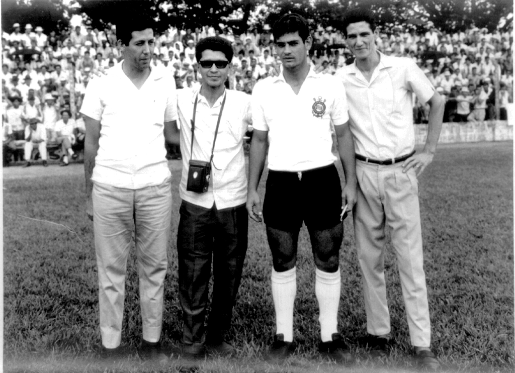 A foto é do ano de 1967 no memorável jogo da Associação Atlética Votuporanguense contra o Corinthians do Rivelino & Cia, que lotou o estádio “Plínio Marin”, conforme pode-se observar ao fundo da foto. A partir da esquerda: José Aparecido Augusto (Rio Preto), o fotógrafo Domingos Olmedo, o jogador Rivelino e Luiz Augusto de Oliveira, o Luiz da Casa Globo. A foto pertence ao arquivo pessoal do Luiz da Casa Globo.