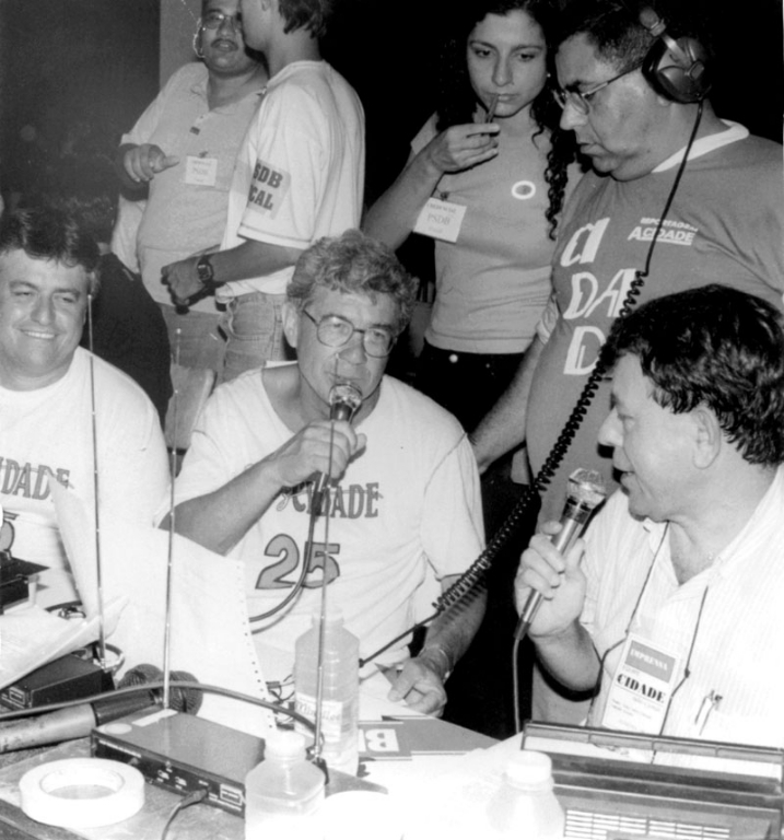 A marcha da apuração - A Rádio Cidade AM sempre comandou a Marcha da Apuração com a contagem dos votos em todas as eleições em Votuporanga. É um marco registrado de audiência na emissora. Nesta foto dos anos 80, a equipe da Rádio Cidade - representada por João Carlos Ferreira e Léo Oliveira Filho - entrevistava os eleitos de Valentim Gentil, o prefeito Felix Jurandir de Lima e o vice Liberato Caldeira. O lema da campanha deles era “Feliz Cidade”, como estampam suas camisas na hora da apuração dos votos.