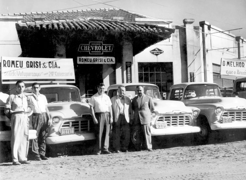 Agência Chevrolet/ anos 50 - A tradicional concessionária Chevrolet de Votuporanga pertencia ao sr. Romeu Grisi. Era uma empresa de grande movimento comercial e muito bem dirigida pela família Grisi. Havia a revenda de veículos novos agregada a uma loja de peças e oficina de revisão e consertos. Não identificamos os personagens que aparecem nesta foto, por certo, um deles é Romeu Grisi. O ato deduzimos que deve ser o lançamento daquela linha de caminhonetes que ganhou, na época, o apelido de “Marta Rocha” (a Miss Brasil)  por ser muito bonita e que tornou-se a paixão daquele tempo.Foto arquivo. 