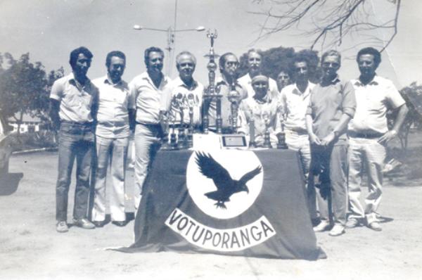 C.T.A  Campeão da Agro-Olimpiada - Ano 1984 - Os troféus simbolizam a conquista importante . O Colégio Técnico Agrícola de Votuporanga foi Campeão Estadual da Agro-Olimpiada, disputada em Presidente Prudente. Da esquerda para a direita: Elcio (vigia), Otávio Falchi (coordenador pedagógico), Nivaldo Melara (Delegado de Ensino), Prof. Valdir Gonçalves de Lima ( supervisor de ensino), Prof. Uélinton Garcia Peres (diretor do Colégio Agrícola), Antonio Flávio Belone (professor de educação física), Eva Maria (professora de criações), Dagoberto José Mira Alves (professor de cultura), Maria Lúcia Vargas (professora de geografia e diretora do grupo teatral) e o professor João Nucci (vice-diretor do C.T.A.). O evento deu-se no dia 12 de setembro de 1984.