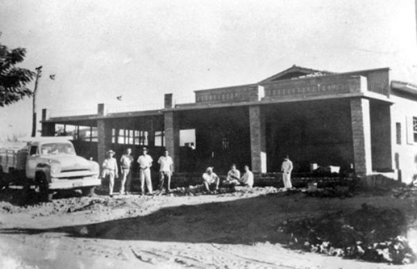 Na foto a construção da casa residencial do senhor Eduardo Tabachi (rua Paraíba, quase esquina com a rua São Paulo). O ano é de 1958. Da esquerda para a direita: Eduardo Tabachi (com o pé no caminhão Studebaker), sr. Mauro, Bráulio da Silva (construtor), Argemiro da Silva (Bibilo/construtor, saudoso jogador do América de Votuporanga), Maurão da Silva (jogador do VEC), Lazão, Joaquim (carpinteiro) e Valmir da Silva (Bibilinho). Veja à esquerda o poste de madeira e dois holofotes da quadra da Escola de Comércio Cruzeiro do Sul, do professor Cícero Barbosa Lima Júnior e dona Chamena. A foto é do arquivo pessoal de João Abbas, que atualmente reside naquela casa.\r\n