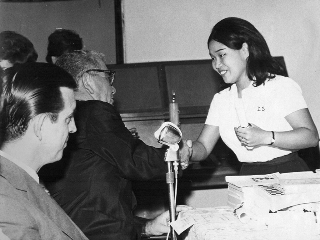 O diretor do Instituto de Educação “Dr. José Manoel Lobo”, Rachid Homsi, cumprimenta a normalista Humiko Takeo na cerimônia de colação de grau dos Professorandos de 1964. O ato é prestigiado pelo então prefeito de Votuporanga, Dalvo Guedes (01/01/1964 a 31/01/1969). Neste ano, Humiko, moradora na Espanha, está comemorando 50 anos de formatura.