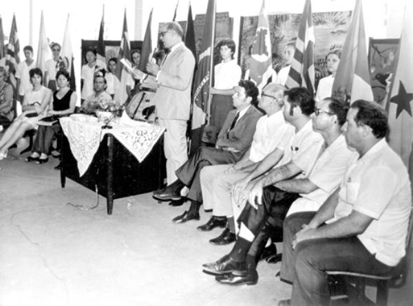 Juramento a bandeira - A foto de Gersino Davanço retrata a cerimônia de Juramento a Bandeira. Antes de 1978, Votuporanga não contava ainda com o Tiro de Guerra e jovens dispensados do Serviço Militar participavam do ato solene de entrega do Certificado de Reservista. Neste evento, destaque para o Prof. Cícero Barbosa Lima Júnior, que aparece discursando. A foto é do tenente Hildebrando dos Santos.\r\n