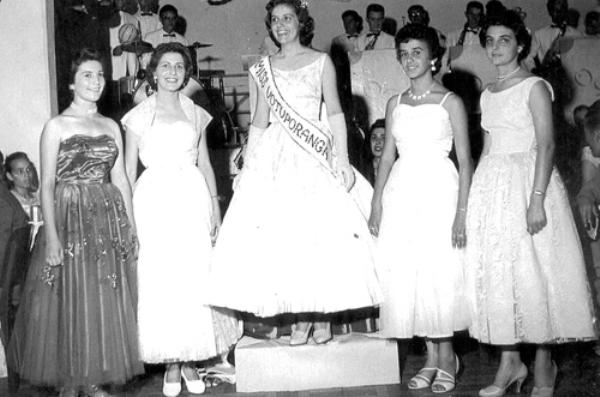 Miss Votuporanga - 1956 - A Miss Votuporanga 1956, DJANE GALLO, recebeu a sua faixa e coroação  no palco do Votuporanga Clube. O concurso foi bastante concorrido e a consagração da eleita deu-se num Baile de Gala, abrilhantado pela Orquestra Guarany. Veja quem são as personagens da foto: Marlene Prado, Ivanilde Mota, a eleita Djane Gallo, Merenice Valente e Neide Públio. Ao fundo, os músicos da Orquestra Guarany: Durvalino, Aluisio, Alvim Algarve, Leopoldo, Oldemar, Oliveira, Rômulo Riva, Tesourinha e Horácio dos Santos. Agradecemos ao saxofonista Eugênio da Silva (Tesourinha), que ajudou na identificação dos músicos da orquestra. A foto pertence ao arquivo pessoal do nosso colaborador Luiz Carlos Murasse - o Serraro.\r\n