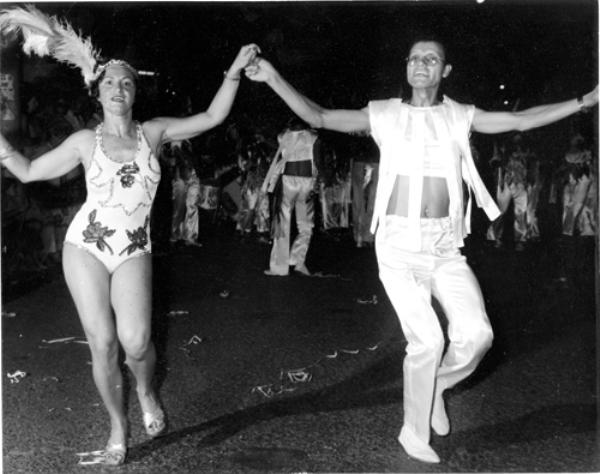 Nélson Ramos Ribeiro, o popular Nélson Ramos da Prefeitura, já teve os seus dias de holofotes. Nesta foto  do Carnaval de 1981 ele mostra o gingado e o samba no pé no desfile carnavalesco na Rua Amazonas. Quem pede passagem como ele é Neusa Dulce Cremonim, durante desfile empolgante da Escola de Samba Acadêmicos do Lago, a Escola do Assary Clube de Campo. A foto é do arquivo familiar.