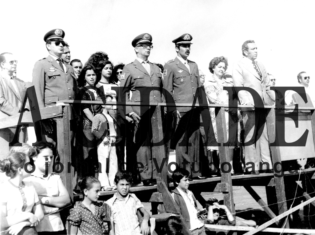 No ano de 1977, no governo do prefeito João  Antonio Nucci, Votuporanga recebeu a visita oficial do Ministro do Exército o general Macedo Soares. Era o auge do militarismo com o presidente da República Gal. Emilio Garrastazu Médici e a cidade recepcionou o ilustre visitante com um desfile cívico/militar na rua  Amazonas. No palanque instalado na praça cívica aparecem entre as autoridades, a partir da esquerda o professor Hudson Paulo Fernandes, do Conservatório Musical de Votuporanga, o Coronel da Polícia Militar Cláudio Manoel Romeiro Junior, o então Capitão do Exército e  Titular da 18.a Delegacia do Serviço Militar  Constantino Santoro, a 1.a Dama da Cidade  Nely Nucci e seu marido, o prefeito João Antonio Nucci.. A direita, podemos identificar os então vereadores José Nunes Pereira e Aguinaldo de Oliveira.

***Confira mais desta coluna em nossa edição impressa e online para assinantes.