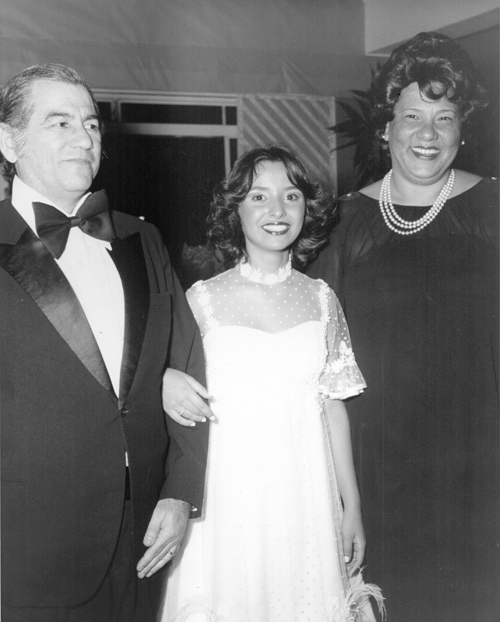 Padrinhos da debutante - Na foto, o médico ginecologista Hermínio Sanches e a sua esposa Maria Célia de Avelar Sanches conduzindo a debutante Carla de Castro Cury para o seu Baile de Gala. O registro é dos anos 80, época de ouro das grandes promoções do Votuporanga Clube. O Baile das Debutantes fazi