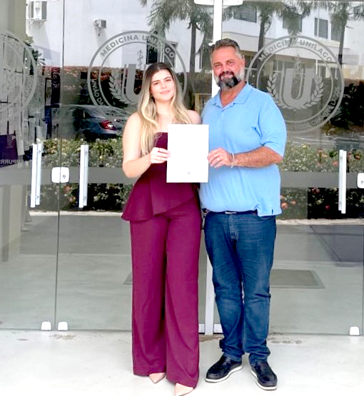 Prosseguindo com as homenagens às mulheres, destacamos a presença de Haline Morato, acompanhada de sua filha Liz Morato Komatsu. Enfermeira e diretora da Protege Vacinas e Cuidados, Haline é um exemplo de liderança, confiança e compromisso com a saúde e o bem-estar de todos. Com sensibilidade, dedicação e um coração repleto de cuidado, ela transforma sua profissão em uma verdadeira missão: proteger, acolher e salvar vidas, inspirando todos ao seu redor.