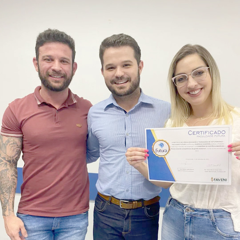 O gestor de políticas acadêmicas Professor Mestre Tiago Moreno entregando certificado para Gabi Caldorim e Fernando Lopes