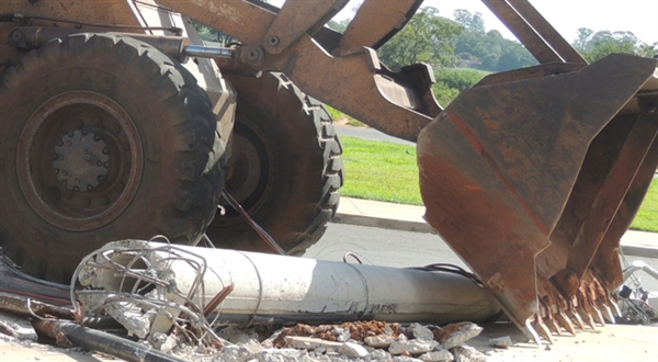 Máquina sobe na calçada e derruba poste 