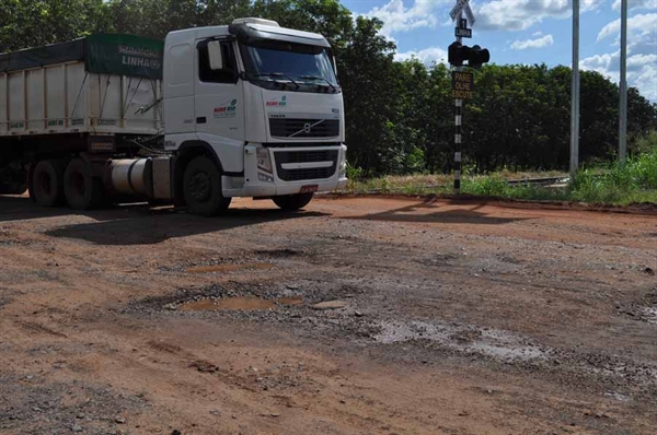 Caminhão desvia de um dos buracos perto da linha do trem