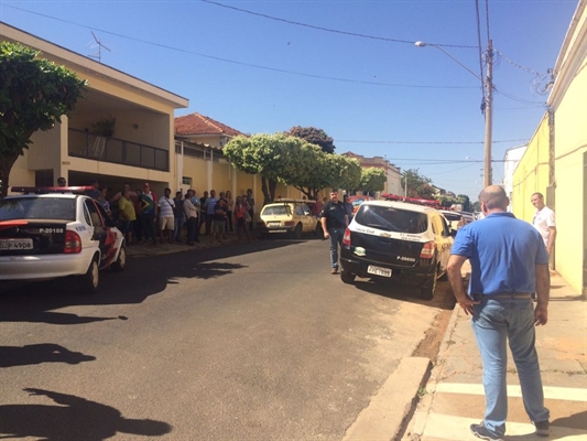 Policiais fazem a reconstituição na rua cercada por curiosos (Foto: Graciela Andrade/TV TEM)