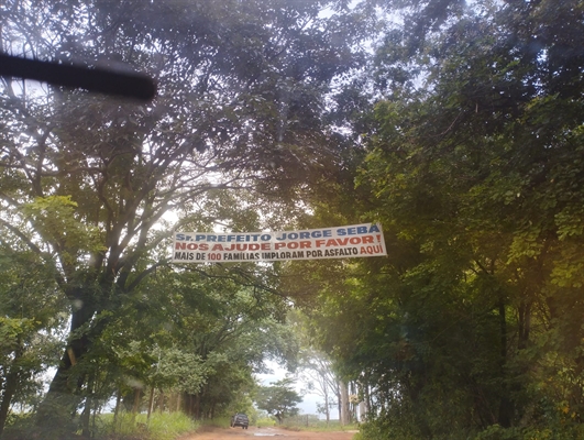 Cansados dos prejuízos que tomam em uma estrada rural, moradores colocaram uma faixa “implorando” por ajuda (Foto: Redes sociais)