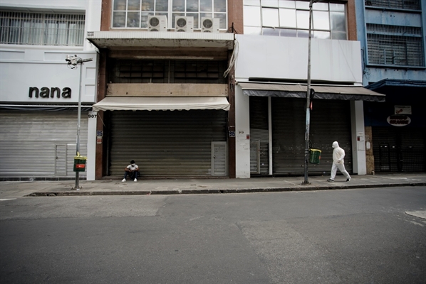 Pessoas passam pela rua 25 de março, em São Paulo, com o comércio fechado  (Foto: Marcelo Brandt/G1)