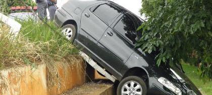 Automóvel bate em alambrado e fica pendurado  