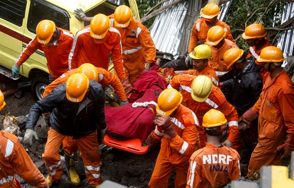 Equipe de resgate tira corpo de escombros de uma queda de muro na cidade de Pune, na Índia — Foto: Stringer/AFP