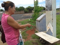 Moradora aponta banco improvisado colocado pelos passageiros em praça do Sonho Meu