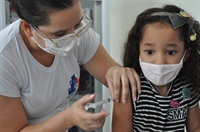 A pequena Heloisa Valeriano, de seis anos, acompanhada de sua mãe, Solange dos Santos, já garantiu a primeira dose da vacina (Foto: A Cidade)