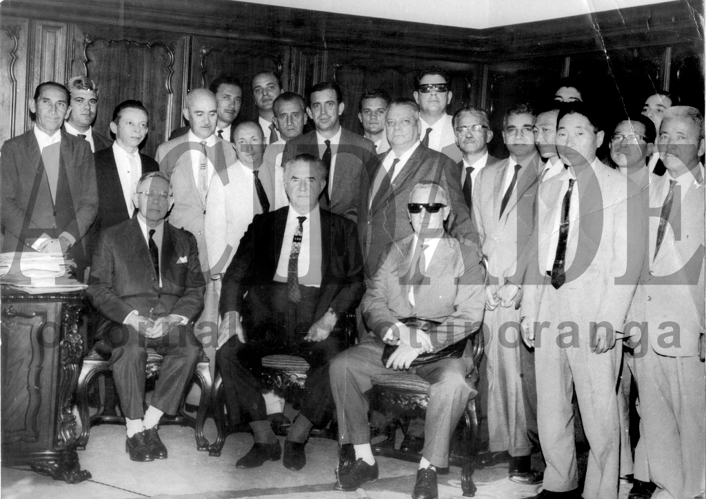 Esta foto é inédita. Por uma questão de princípios, o prefeito Dalvo Guedes guardou este registro fotográfico a sete chaves por muitos anos. Dessa comitiva, somente Domingos Pignatari tinha conhecimento que Dalvo possuía cópia da foto da visita do governador. Corria no ano de 1964 e o adhemarista Leonidas Pereira de Almeida (Capitão Almeida) deu sinal verde para o Adhemarzão atender Votuporanga. Naquela audiência foi liberada a criação da Inspetoria de Ensino e nomeado titular o professor Benedito Israel Duarte; saiu a instalação do Instituto de Educação (havia sido criado, mas ainda não havia sido instalado); Delegacia Regional de Polícia e Delegacia Regional de Saúde. Aparecem na foto, a partir da esquerda, de pé: Antonio Pagliarani, Abilio Calille, Domingos Pignatari, Aziz José Abdo, professor Aloísio Valente, Dr. Ruy Pedroso, Roberto Sayeg, Octávio Viscardi, Dalvo Guedes, Fleury Angelo Cecchini, Capitão Leonidas Pereira de Almeida, o filho deste Leco, Dr. Joaquim Franco Garcia, Marão Abdo Alfagalli, representantes da Colonia Japonesa e, atrás, Horácio Correia de Moraes. Sentados: o secretário da educação Olhoa Cintra, o governador Adhemar de Barros e o professor Floriano Marzochi.

***Confira mais desta coluna em nossa edição impressa e online para assinantes.