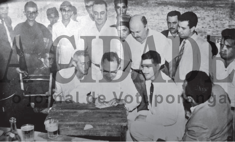 Esta foto é histórica.O ano é 1956 - na semana do Natal. E com esta assinatura do deputado estadual Dr. Anísio José Moreira nasceu a Associação Atlética Votuporanguense uma das glórias do futebol do interior. Existiam na cidade dois times rivais. O VEC - Votuporanga Esporte Clube tinha como presidente o Sr. José Silva Melo (Zéquinha Alfaiate), e o América Futebol Clube, na época sob a presidência do Rachidinho (funcionário da Prefeitura Municipal). Os homens que aparecem nesta foto foram os articuladores da fusão, os responsáveis direto pelo surgimento da AA Votuporanguense. Confira a partir da esquerda quem são esses pioneiros do esporte. Em pé: Nélson Maraldi, Ozório Casado, Arquimedes Neves (o Nei), ? , Moacir Másquio (Nininho), Vicente Castrequini, Lula, Zézinho Marão, dr. Martiniano Salgado, ? , Carlos Márcio de Castro Junqueira, e Deolindo Trindade (Frinfa). Agachados na mesma ordem: o primeiro não identificado, Alfredo Rodrigues Simões (Cavaco), ao centro o deputado estadual Dr. Anísidio José Moreira, Plínio Marin, e de costas Emílio Liévana Torres (o Torrinha). A foto pertence ao ex-vereador Ozório Casado e a identificação das personalidades foram feitas pelo nosso colaborador Dagoberto José Mira Alves (Dago).

***Confira mais desta coluna em nossa edição impressa e online para assinantes.