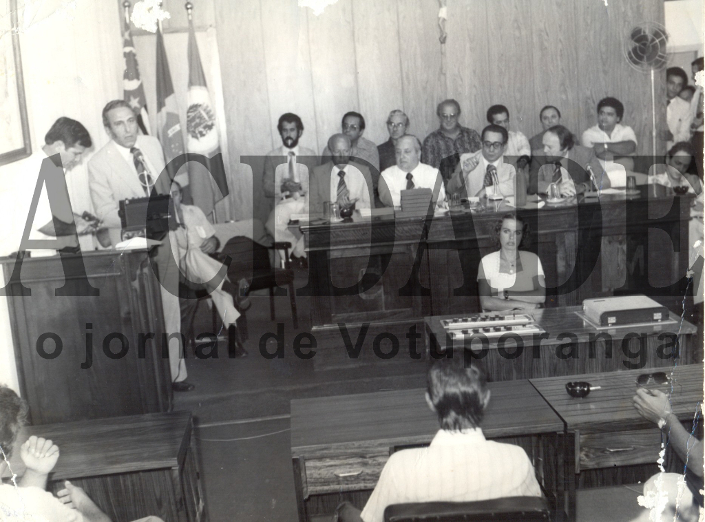 Em concorrida reunião na Câmara Municipal, no prédio da Prefeitura, onde hoje está o gabinete do prefeito, autoridades visitantes foram homenageadas. Na tribuna, discursa o então prefeito João Antonio Nucci (ao lado do vereador Alzimiro Brantis) e na mesa central aparecem o deputado Waldemar Lopes Ferraz, senador Amaral Furlan, o viceprefeito Onofre de Paula, o então vice-governador José Maria Marim e o então deputado estadual Alvaro Fraga. Na segunda fileira: Antonio Benedito Malvas, o delegado Seccional  de Polícia Antonio Fontes, ? , Fernando Vendramini (Mirassol), outros dois não identificados e o juiz de direito Antonio Correia. Na frente, modulando o som ambiente, a funcionária Vera.

***Confira mais desta coluna em nossa edição impressa e online para assinantes.